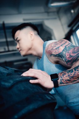 Genç sporcunun ağır lastik spor salonunda saygısız yan görünüm