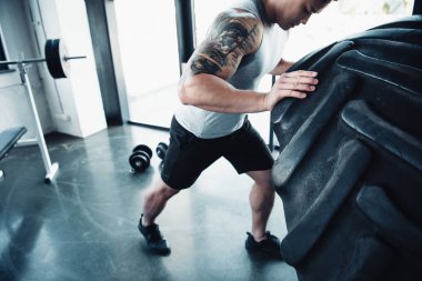 Genç sporcunun ağır lastik spor salonunda saygısız görünümünü kırpılmış