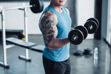 kısmi genç sporcu spor salonunda dumbbells ile egzersiz görünümünü