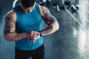 dövmeli genç sporcu bakarak spor salonunda görünümünü kırpılmış