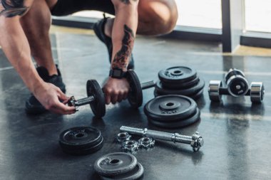 dövmeli sporcu dumbbells montaj kısmi görünümünü