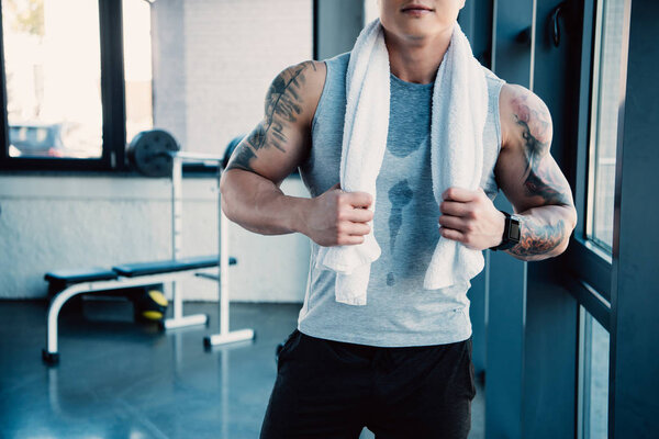 частичный молодой спортсмен с белым полотенцем после долгой тренировки
