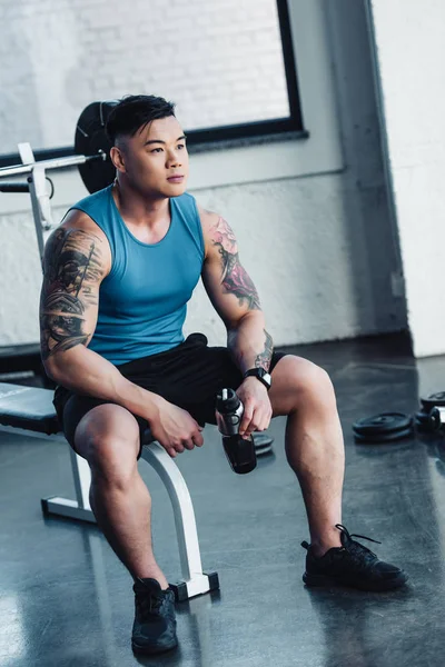 Apuesto Joven Deportista Sentado Gimnasio Con Botella Agua — Foto de stock gratuita