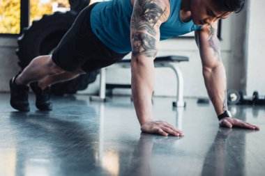 genç sporcu spor salonunda tahta egzersiz yaparak kırpılmış görünümünü