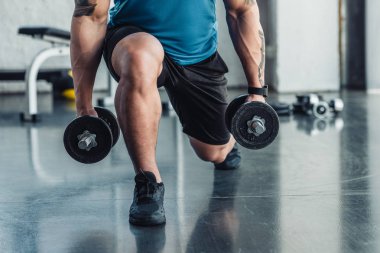 kısmi genç sporcu spor salonunda dumbbells ile egzersiz görünümünü
