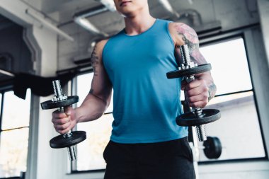 kısmi genç sporcu spor salonunda dumbbells ile egzersiz görünümünü