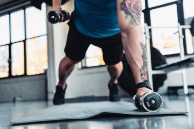 genç sporcu spor mat spor salonunda dumbbells ile egzersiz