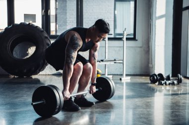 konsantre sporcu spor salonunda barbell ile eğitim