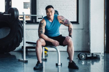 yakışıklı genç sporcu spor salonunda oturuyor 