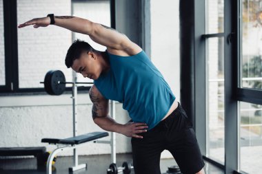 genç sporcu spor salonunda germe egzersiz yaparak