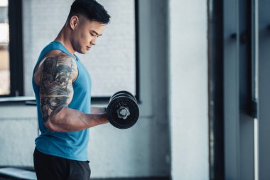 genç sporcu ile halter salonunda egzersiz yan görünüm konsantre