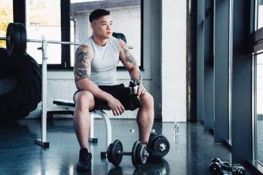genç sporcu spor salonunda dumbbells ile egzersiz konsantre