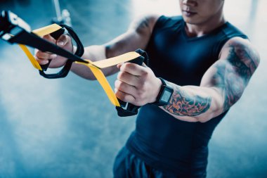 spor salonunda direnç gruplarla eğitim genç kaslı sporcu kırpılmış görünümünü
