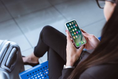 havaalanında gidiş salonunda oturuyor ve smartphone kullanarak genç iş kadını