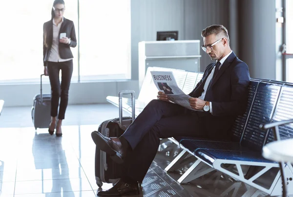 Vuxen Affärsman Läsa Tidningen Samtidigt Som Affärskvinna Promenader Med Bagage — Stockfoto