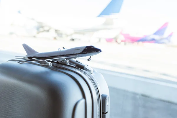 Szürke Bőrönd Repülőtéren Kis Repülőgép Modell Közelről — Stock Fotó
