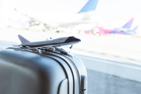 close up of small plane model on grey suitcase in airport