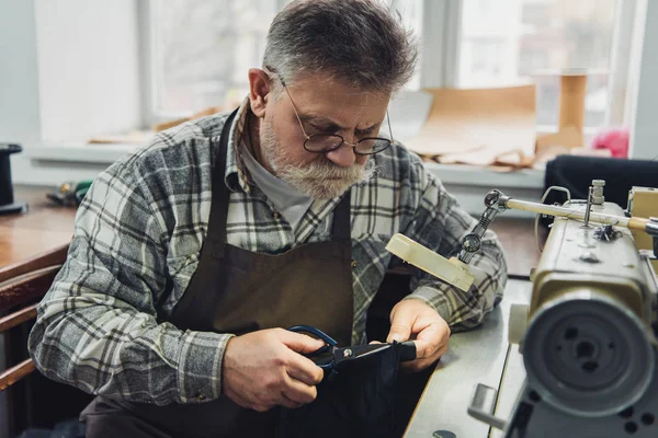 Mature Male Tailor Eyeglasses Apron Cutting Leather Scissors Workshop — Stock Photo, Image