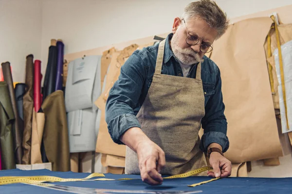 Foco Seletivo Artesão Meia Idade Masculino Avental Fazendo Medições Tecido — Fotografia de Stock Grátis