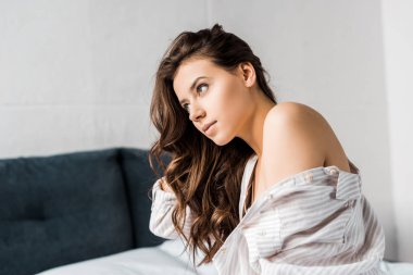 Sabahleyin yatağın üstüne oturan ihale esmer kadın