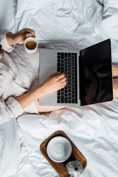 Cropped View Woman Coffee Cup Using Laptop Bed — Free Stock Photo