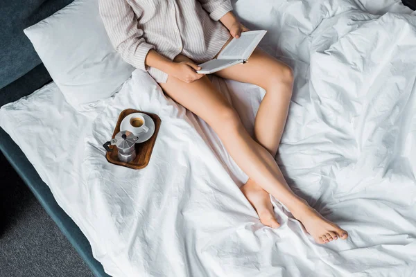 Обрезанный Вид Девочки Читающей Книгу Постели Чашкой Кофе Кастрюлей Моки — Бесплатное стоковое фото