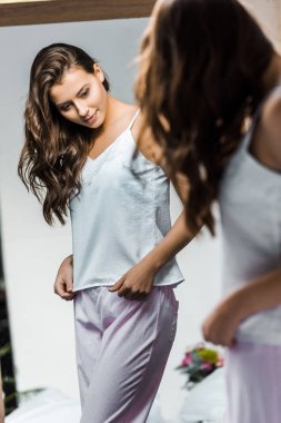 güzel ince kız onu aynada yansıması bakarak pijama