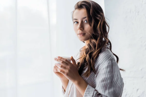 Mooie Brunette Meisje Permanent Met Kop Koffie Buurt Van Venster — Gratis stockfoto