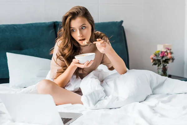 Mujer Sorprendida Comiendo Avena Para Desayuno Viendo Algo Ordenador Portátil — Foto de Stock