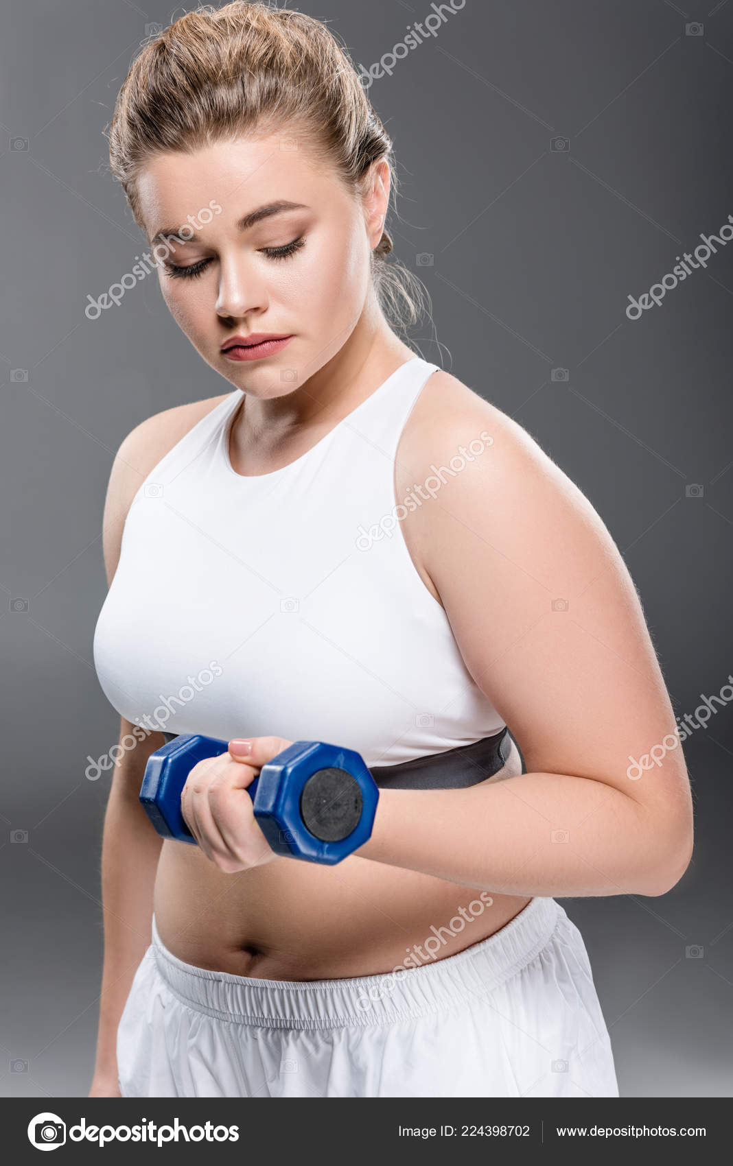 若いサイズ プラス グレーに分離されたダンベル運動の女性 無料のストック写真 C Allaserebrina