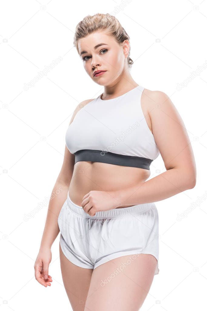 young size plus woman in sportswear looking at camera isolated on white