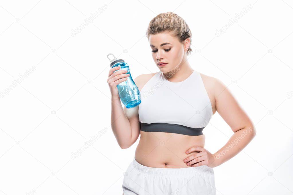oversize girl in sportswear holding bottle of water isolated on white