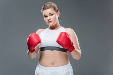 çekici boyutu artı kadın spor giyim ve boks eldivenleri gri izole kamera bakıyor 