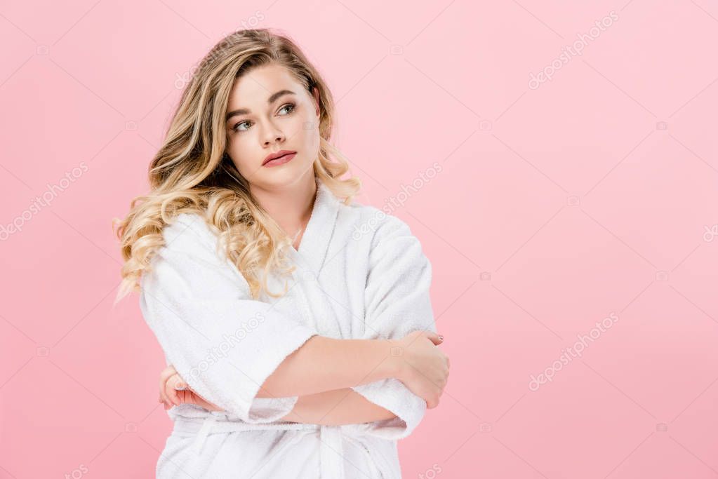 beautiful overweight girl in bathrobe standing with crossed arms and looking away isolated on pink