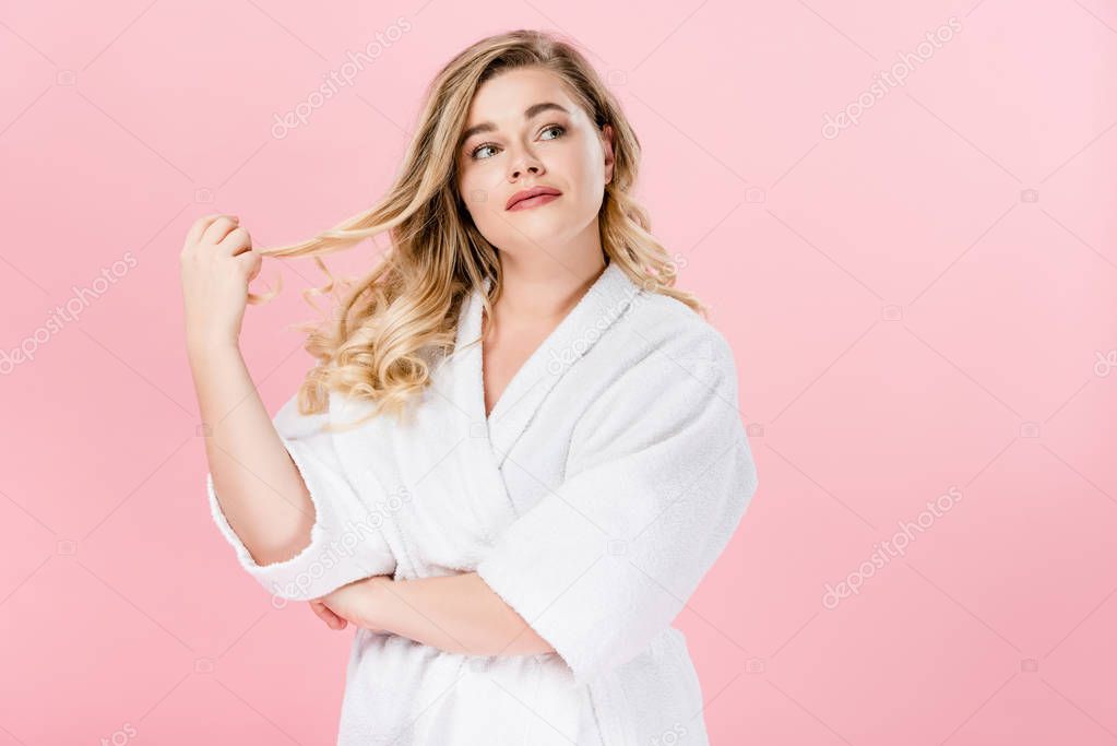 pensive beautiful oversize girl in bathrobe looking away isolated on pink