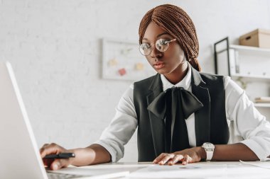 çekici bilgisayar masası oturma ve çalışma office bardaklarda Afro-Amerikan yetişkin işkadını odaklı