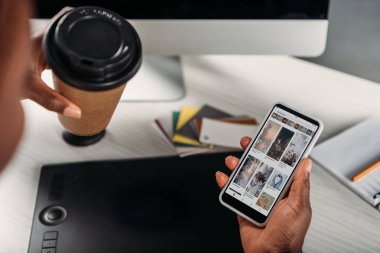 gitmek için kahve tutan Afrikalı-Amerikalı kadın işkadını ve smartphone ile pinterest app kırpılmış görünümünü ekranda
