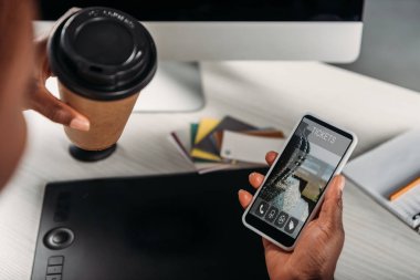 gitmek için kahve tutan Afrikalı-Amerikalı kadın işkadını ve smartphone ile Bilet online app kırpılmış görünümünü ekranda