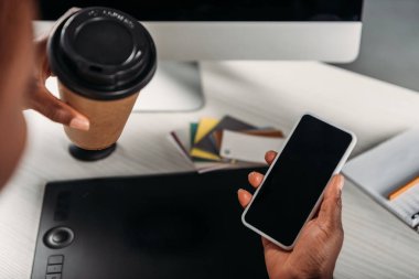 kırpılmış görünümü ile boş perde smartphone ve gitmek için kahve tutan Afrikalı-Amerikalı kadın iş kadını