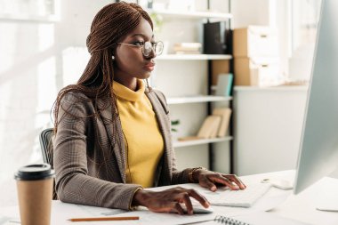 bilgisayar masası oturma ve çalışma office Afro-Amerikan işkadını odaklı