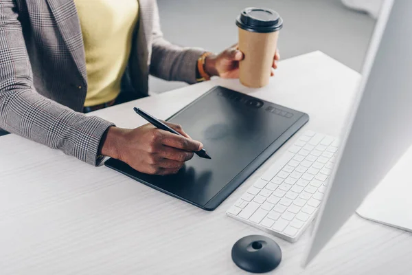 Vista Parcial Del Diseñador Afroamericano Sosteniendo Café Para Llevar Utilizando — Foto de Stock