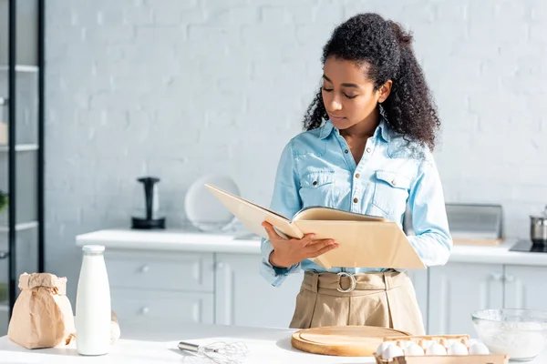 Attractive African American Woman Reading Cookbook Kitchen — Stock Photo, Image