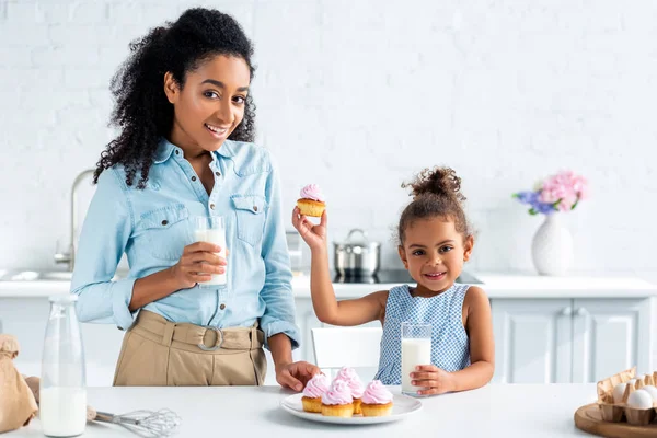 African American Matka Córka Trzymając Szklanek Mleka Ciastko Kuchni — Zdjęcie stockowe