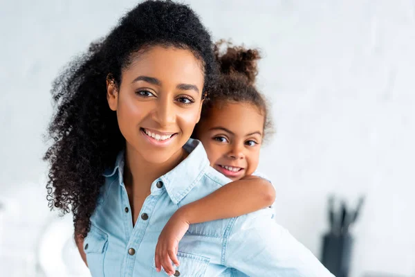 Cheerful African American Mother Giving Piggyback Adorable Daughter Kitchen — Stock Photo, Image
