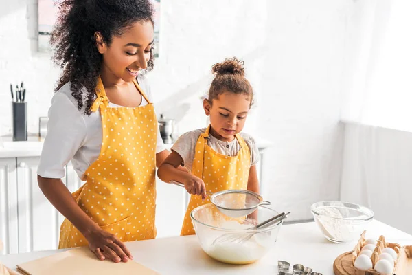 Cheerful African American Mother Daughter Preparing Dough Sieving Flour Kitchen — Stock Photo, Image