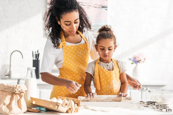 African American Mother Looking Daughter Rolling Dough Rolling Pin Kitchen — Free Stock Photo