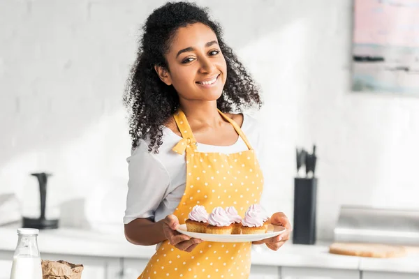 Menina Americana Africana Atraente Avental Segurando Cupcakes Caseiros Olhando Para — Fotografia de Stock