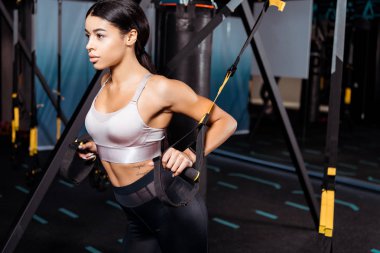  Güzel sportif kız ile süspansiyon askıları spor salonunda egzersiz 