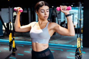 Sportif kız fitness salonunda dumbbells ile eğitim  