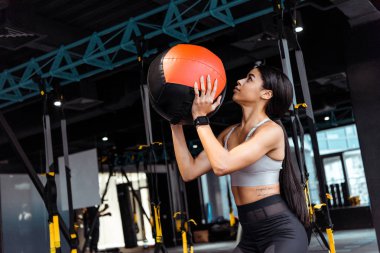 Çekici sportif kız fitness salonunda sağlık topu ile eğitim